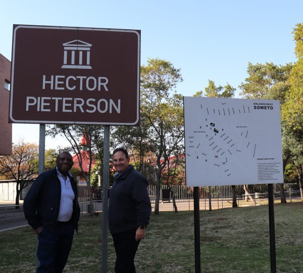 MaxProf Executive Chairman and COO posing infront of Hector Pieterson street sign