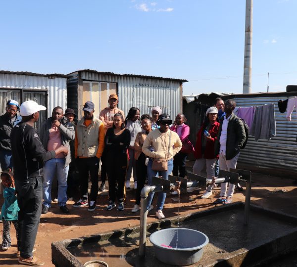 MaxProf employees listening to community representative render the daily life of a Nomzamo dweller